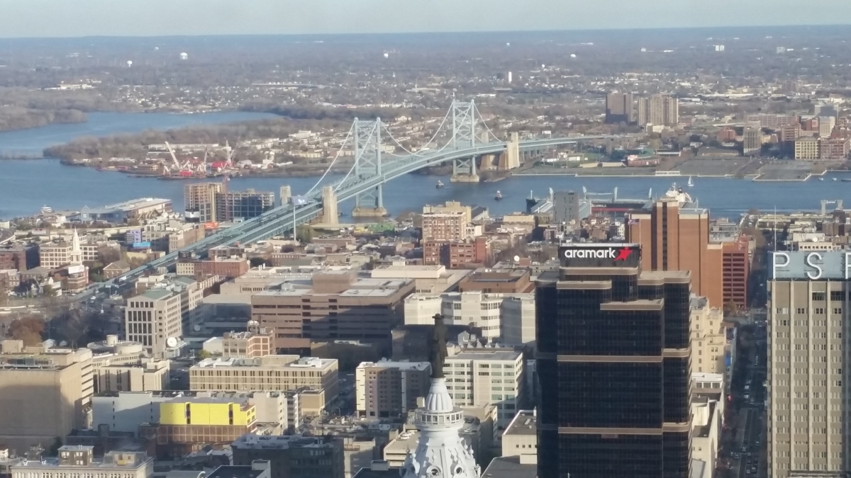 William Penn atop City Hall is in the foreground with the Benjamin Franklin Bridge in the background
